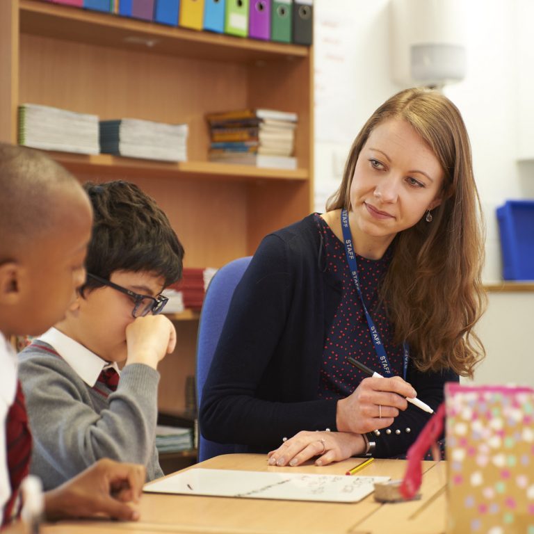 Female teacher listening to schoolboys in a classroom at The Mall School