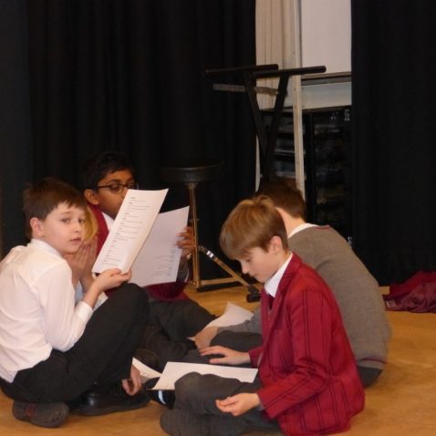 boys talking and reading scripts amongst themselves