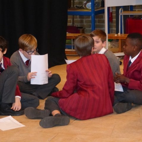 boys talking and reading scripts amongst themselves