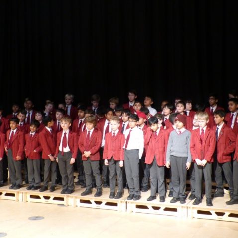 A large group of boys from the choir singing