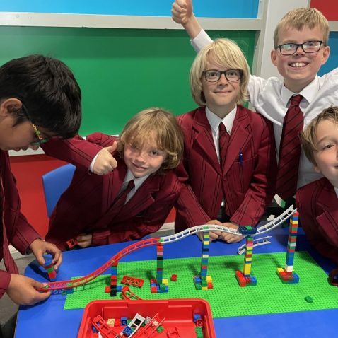 group of school boys building lego structures