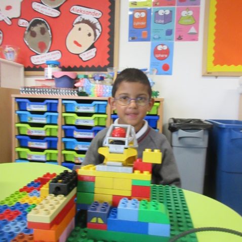 school boy playing with lego blocks