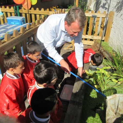 reception children with their teacher. studying pond life