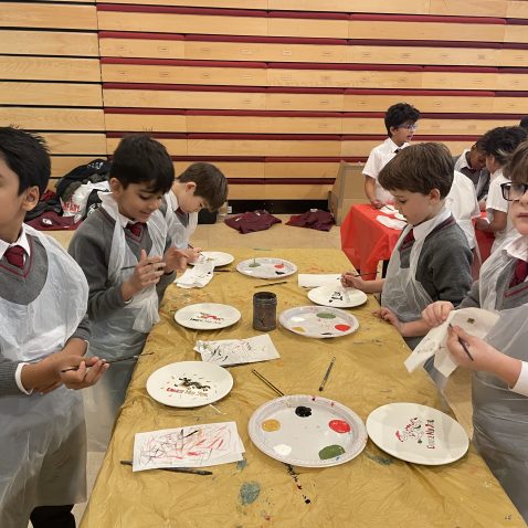 children holding their paint brushes