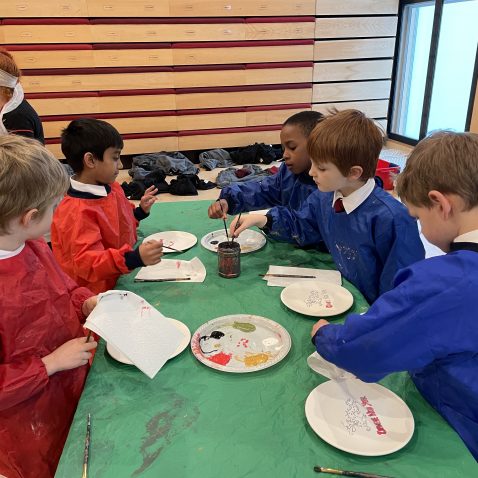 children wearing aprons and painting