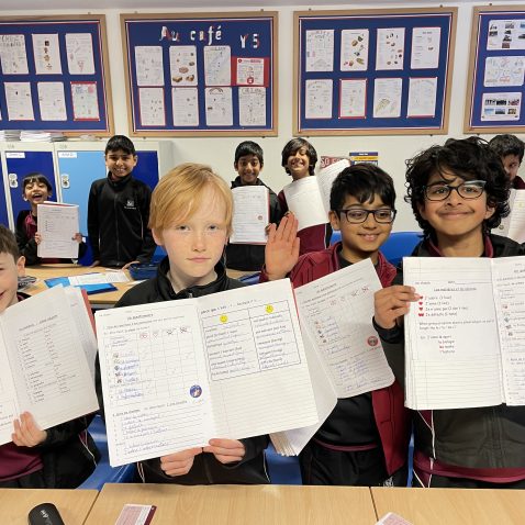 children holding their books up