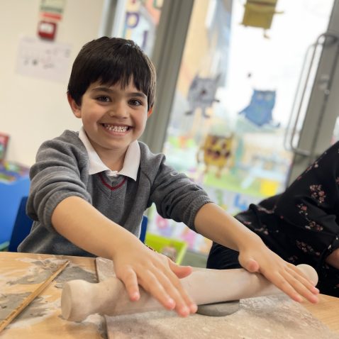 student making clay shapes