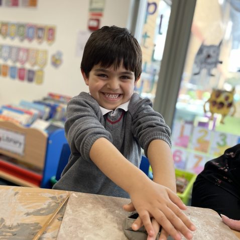 student making clay shapes