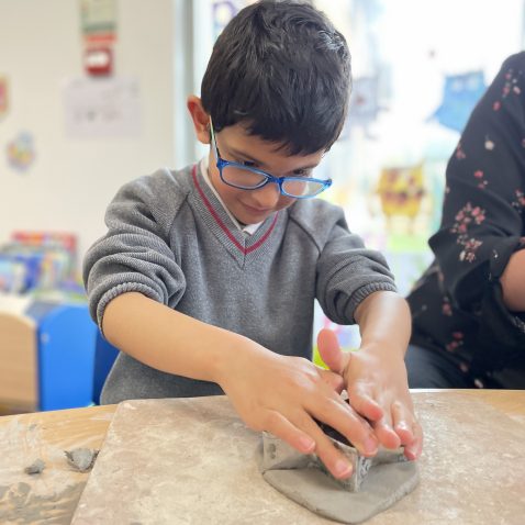 student using stencil for clay