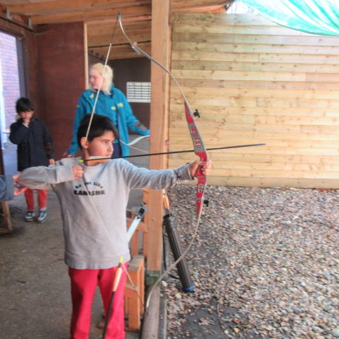 student using a bow and arrow