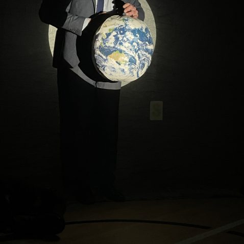 teacher holding a globe up