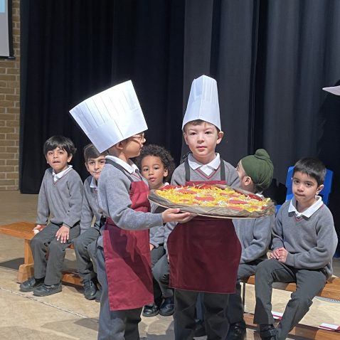 boys holding a model pizza