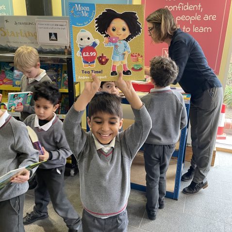 child holding a book up over his head