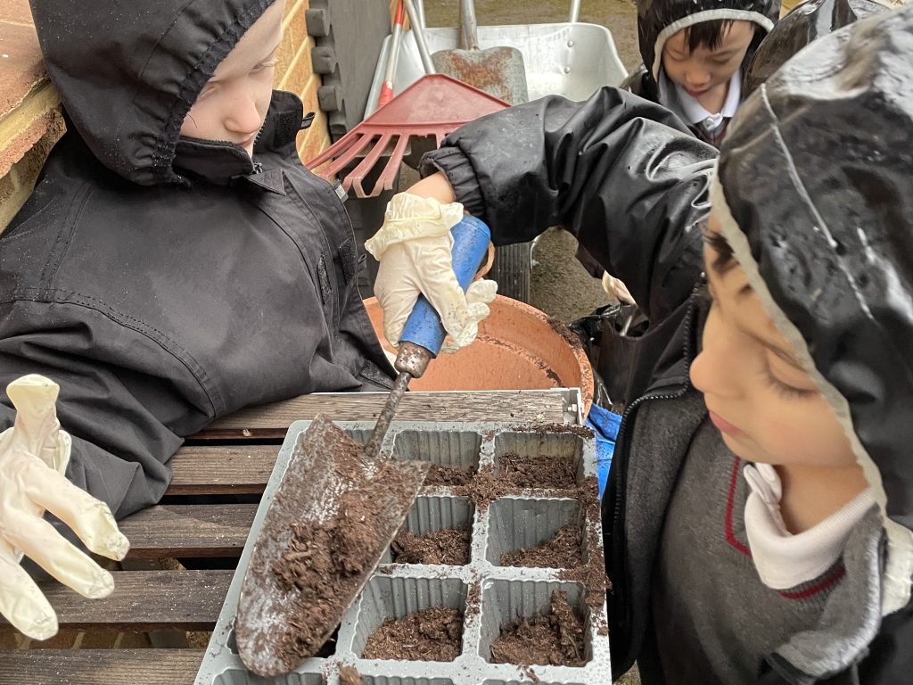 students filling out pots with soil