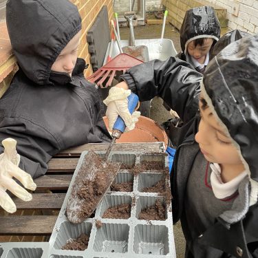 students filling out pots with soil