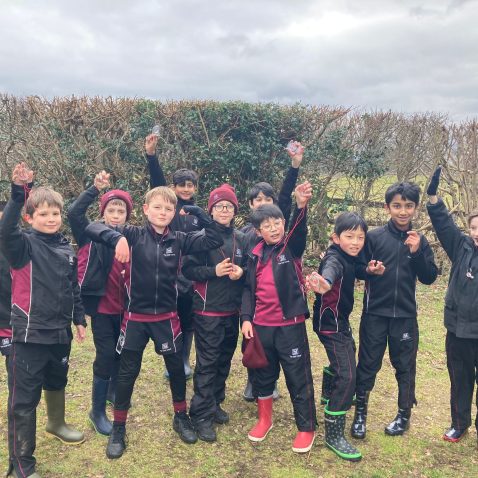 students with their compasses raised in the air