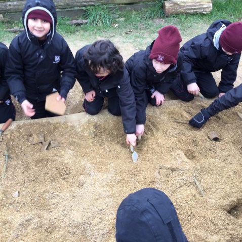 students digging out dirt using trowels