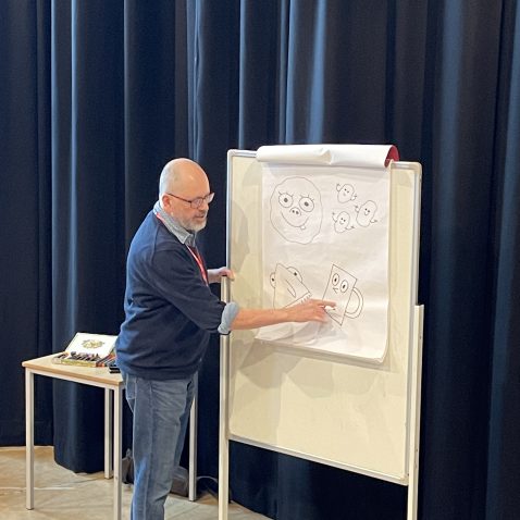 teacher pointing at a drawing on a flip chart