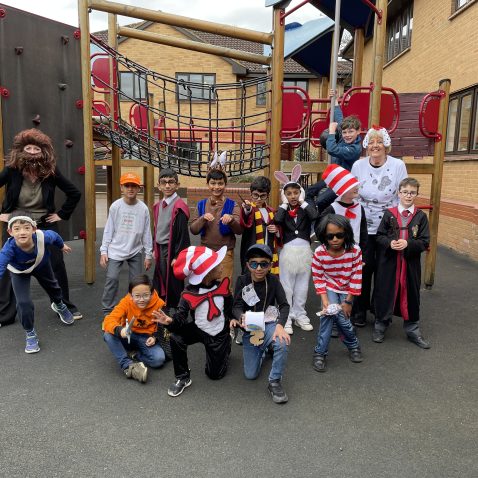 students and teachers dressed up for World Book Day, posing outside in our playground