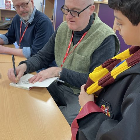 an author signs a student's book
