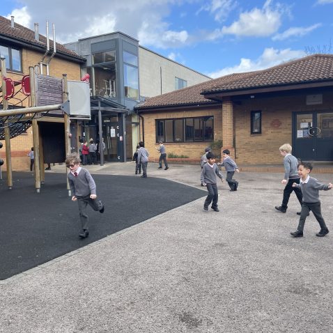 young boys running around the playground