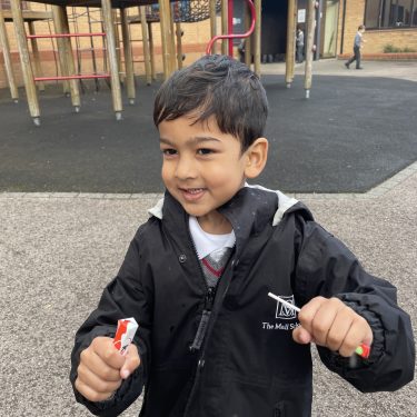 student holding 2 lollipops in his hands