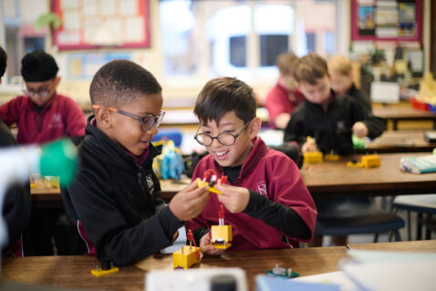 Two schoolboys in The Mall School uniform, are building a mini circuit in the Science lab