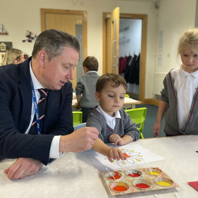 Reception children mixing paint colours in the classroom