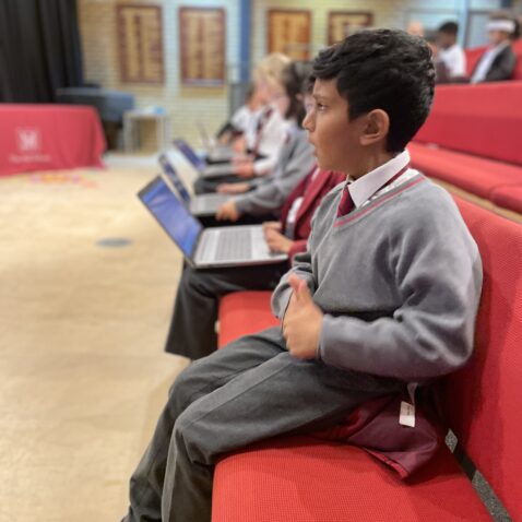 Pupils sitting on the front bench seat in The Mall Theatre