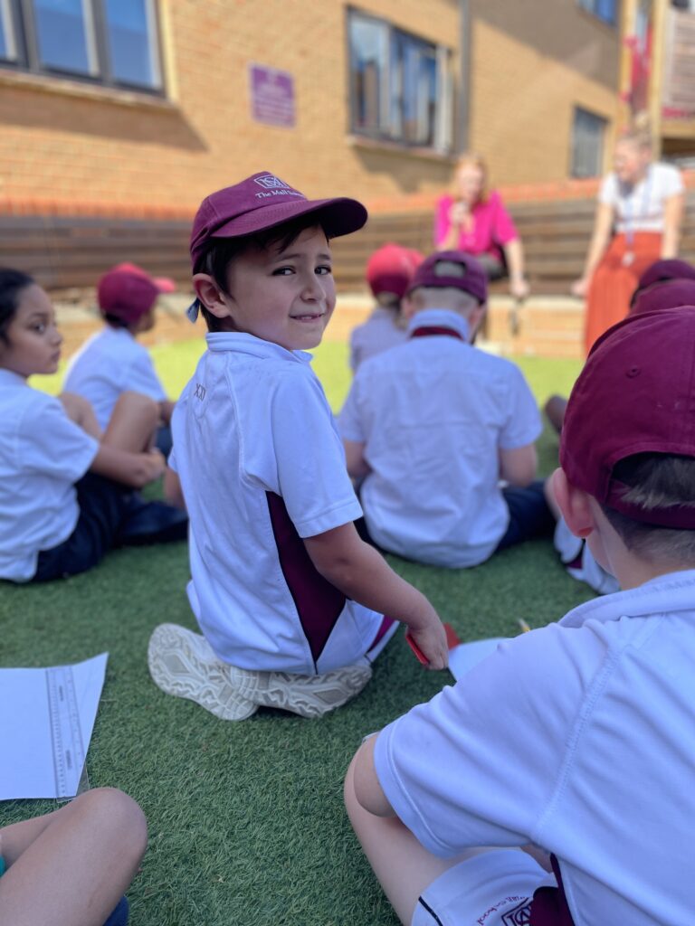 One schoolboy turning to look at the camera whilst his friends are facing forwards