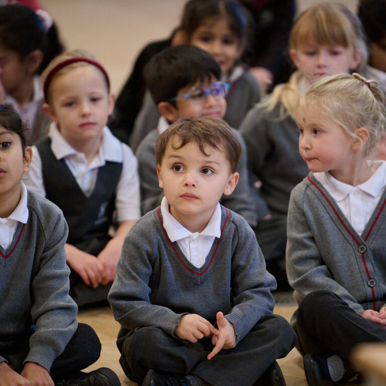 Junior pupils sitting on the floor for Assembly