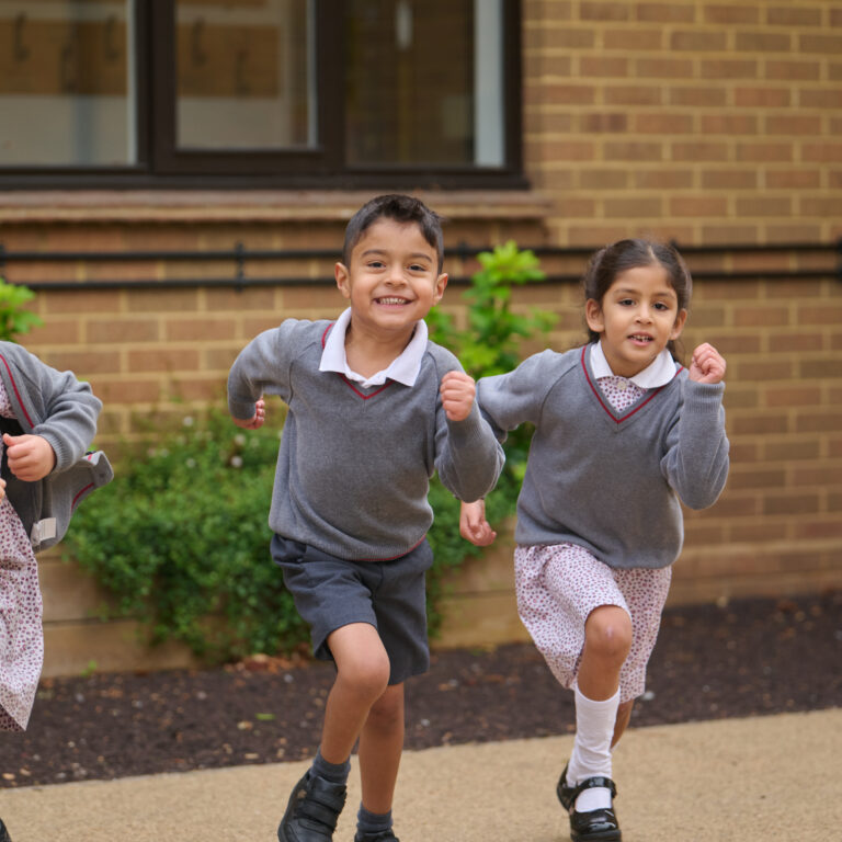 Junior pupils running through playground